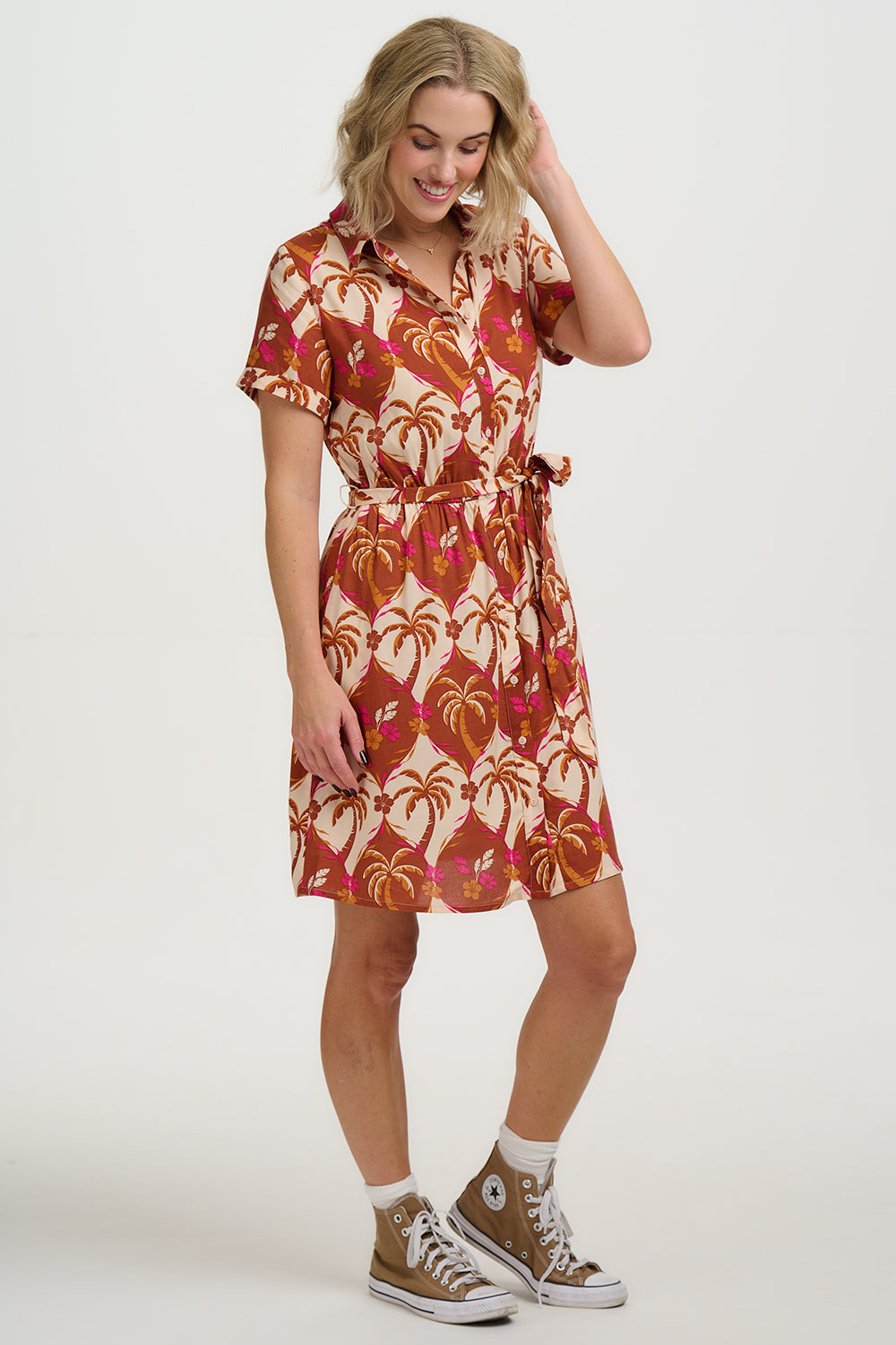 Woman wearing a patterned dress with a plain background