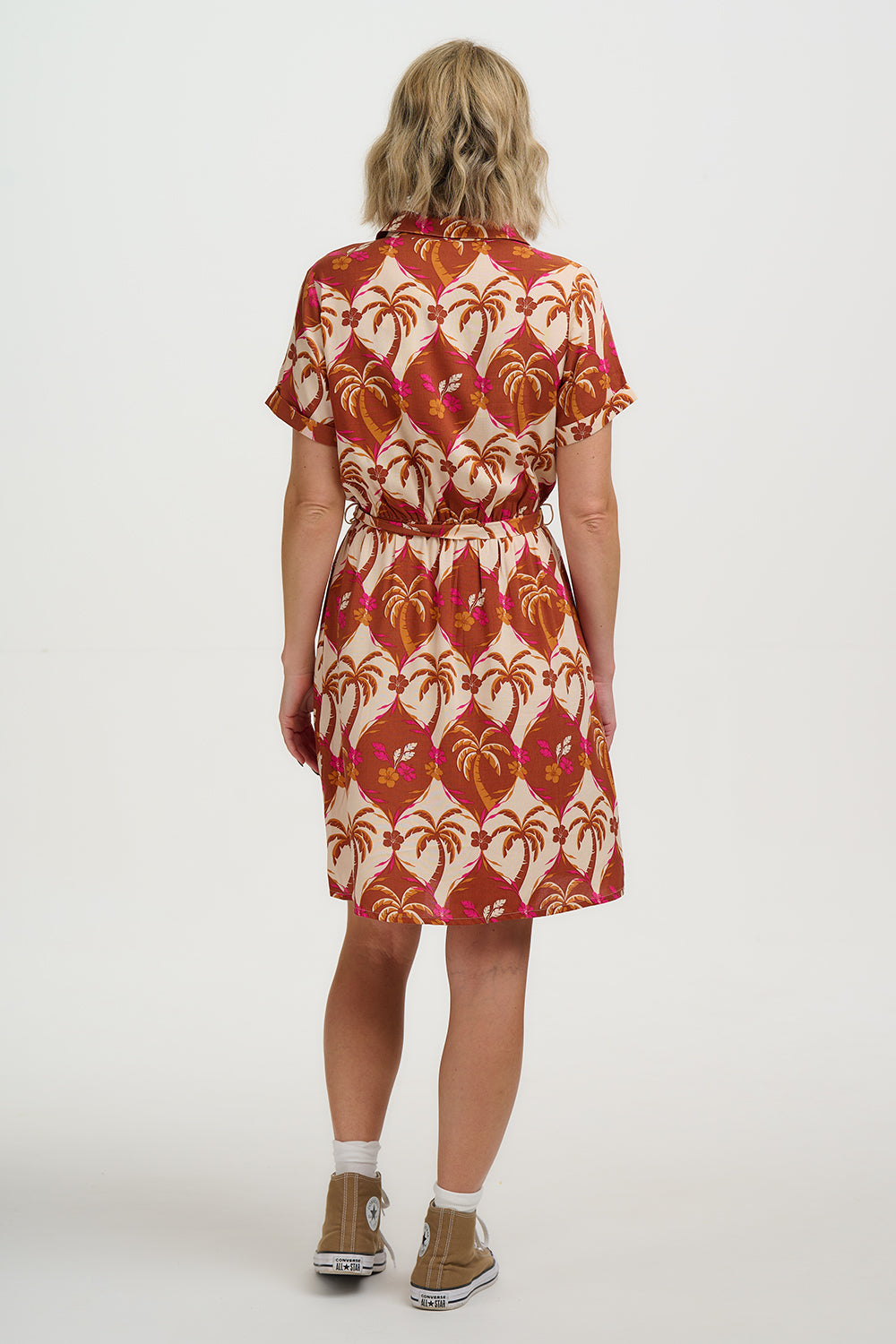Person wearing a patterned dress with a white background