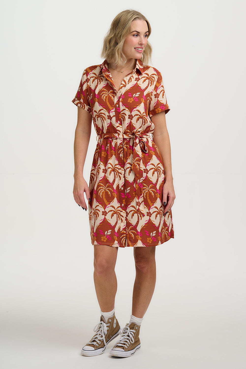 Woman wearing a patterned dress with a plain background