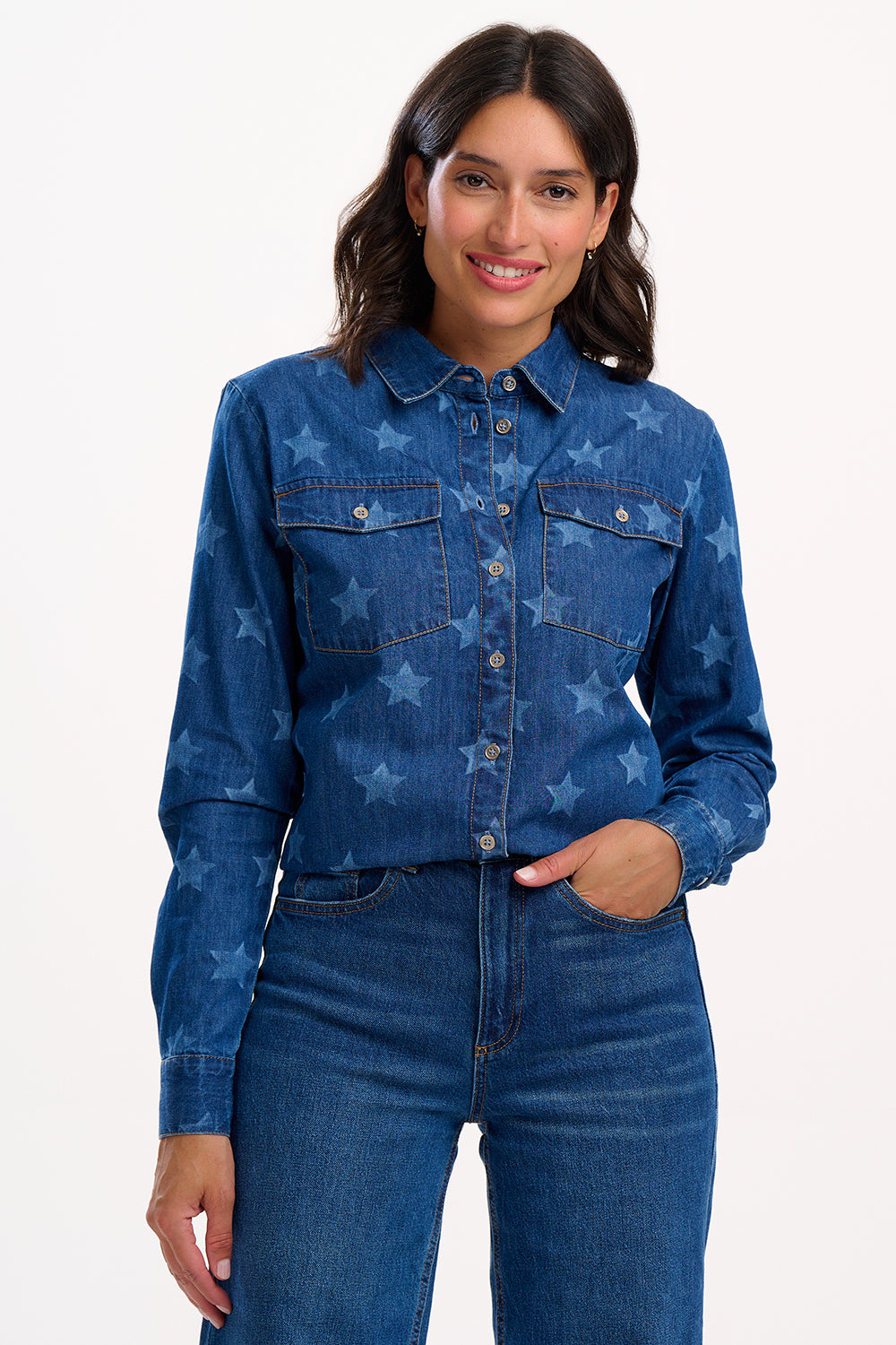 Woman wearing a blue denim shirt with star patterns on a white background