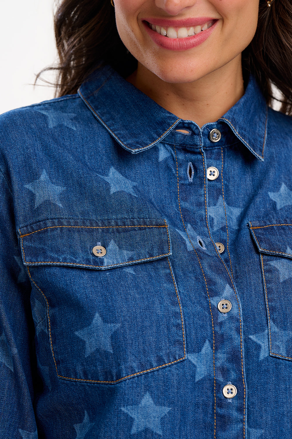 Close-up of a person wearing a blue denim shirt with star pattern