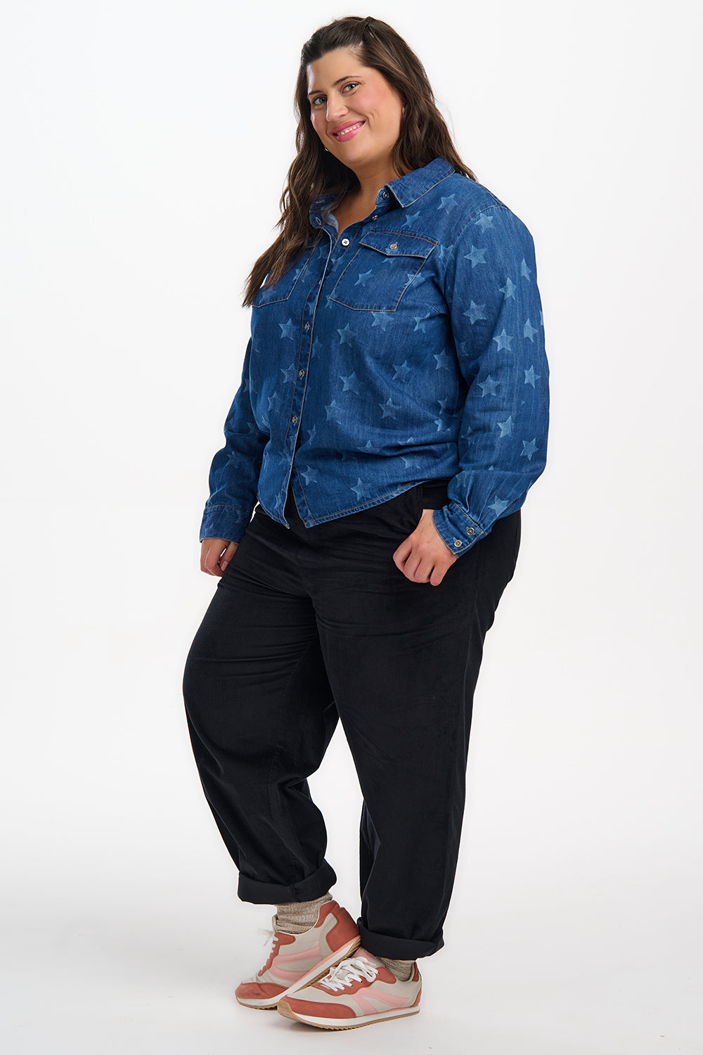 Woman wearing a blue denim jacket with star pattern on a white background