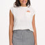 A woman wearing a classic mini skirt with monochrome pinstripes in black and white. She is also wearing a white top with a visible logo on the chest.