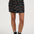 Person wearing a black floral skirt with a plain background