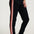 Black jogger pants with red and pink side stripes worn by a person on a white background