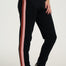 Black jogger pants with red and pink side stripes worn by a person on a white background