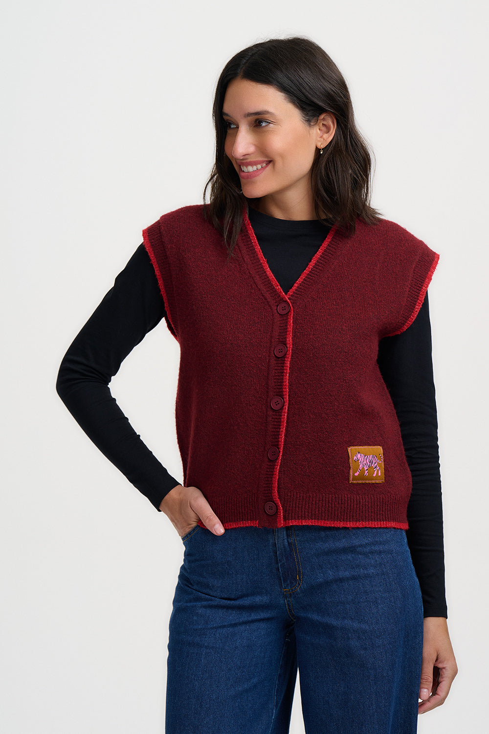 Woman wearing a red vest with a logo on a white background