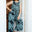Woman wearing a patterned jumpsuit standing in a doorway.