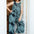 Woman wearing a patterned jumpsuit standing in a doorway.