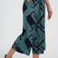 Person wearing teal and black patterned pants on a white background