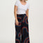 A model wearing black cropped wide-leg trousers with a geometric multicolour pattern, paired with a white top.
