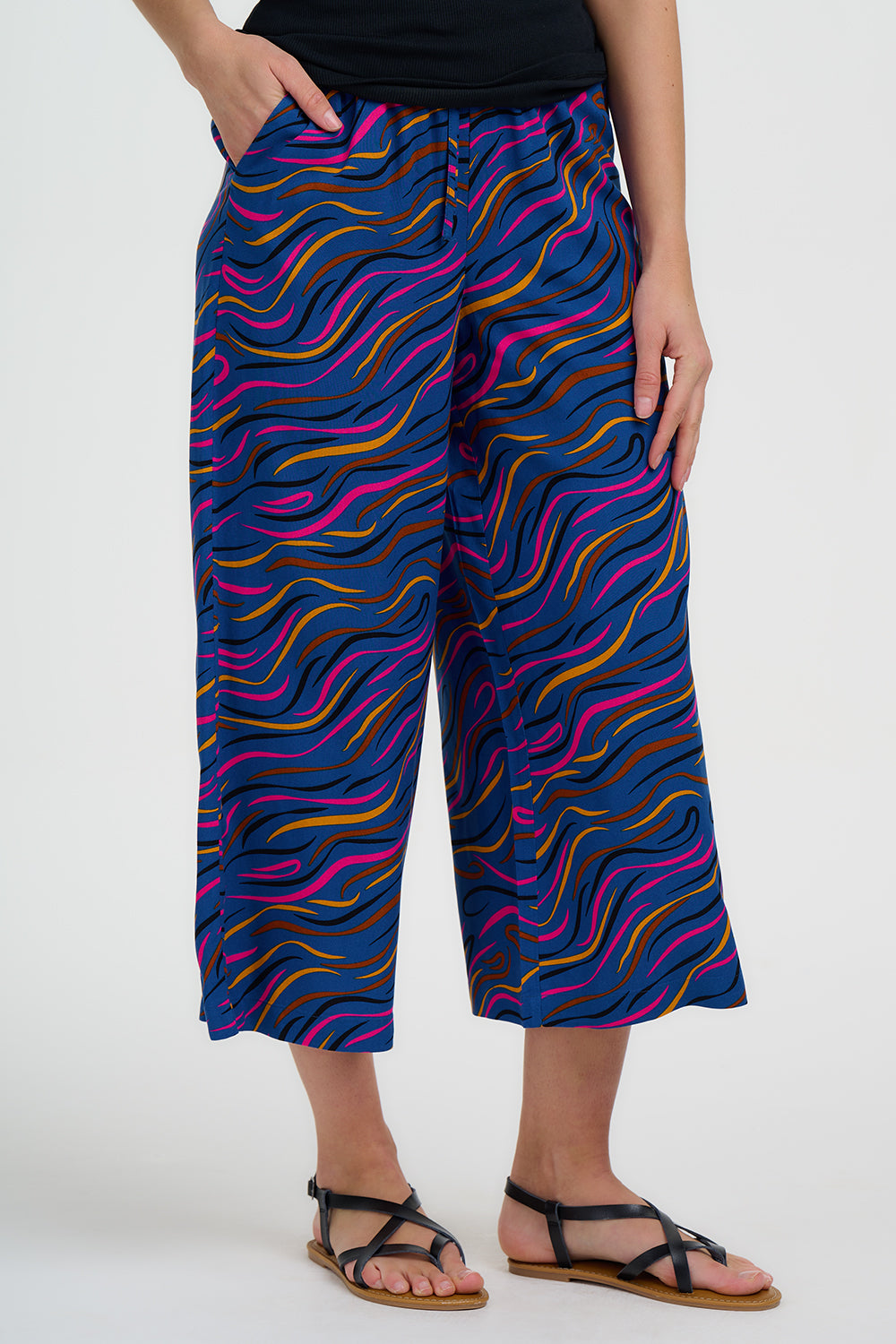 Person wearing colorful wavy-patterned pants on a white background