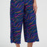 Person wearing colorful wavy-patterned pants on a white background