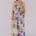 Woman wearing a colorful geometric patterned jumpsuit against a plain background