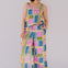 Woman wearing a colorful geometric patterned jumpsuit against a plain background