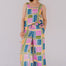 Woman wearing a colorful geometric patterned jumpsuit against a plain background