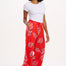 A woman modeling red cropped wide-leg trousers with a Rainbow Fronds print, paired with a white top and white sandals.
