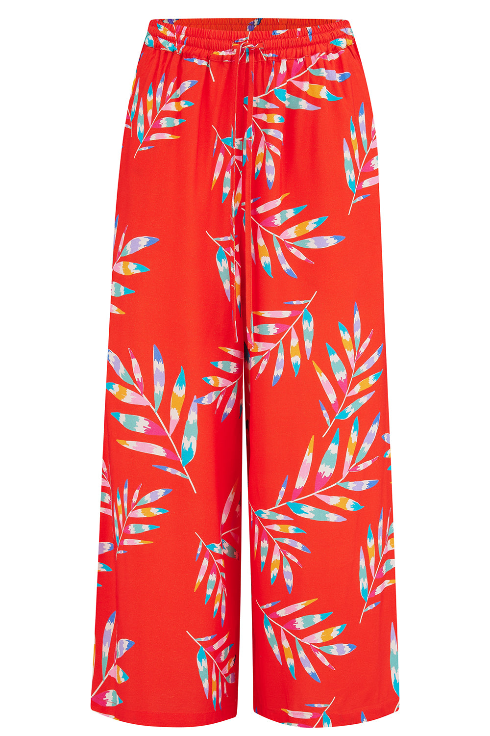 A woman modeling red cropped wide-leg trousers with a Rainbow Fronds print, paired with a white top and white sandals.