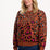 Woman wearing a brown sweater with colorful leopard print pattern on a white background