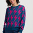 Woman wearing a blue sweater with pink lightning bolt pattern on a white background