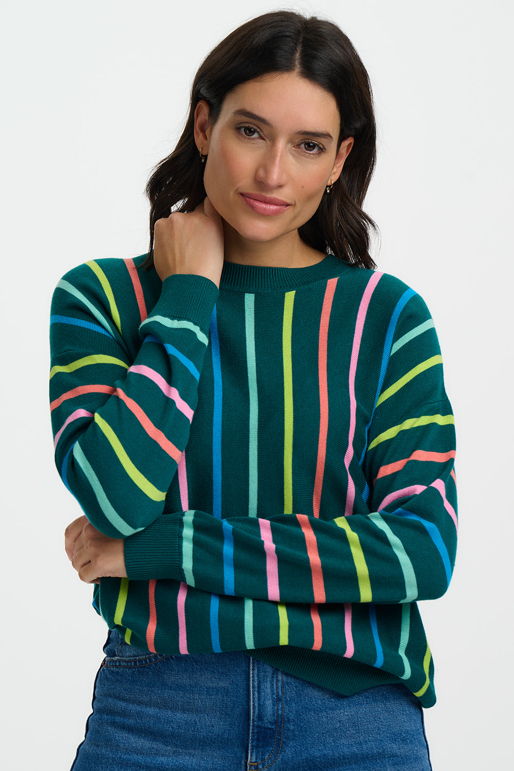 Woman wearing a colorful striped sweater against a white background