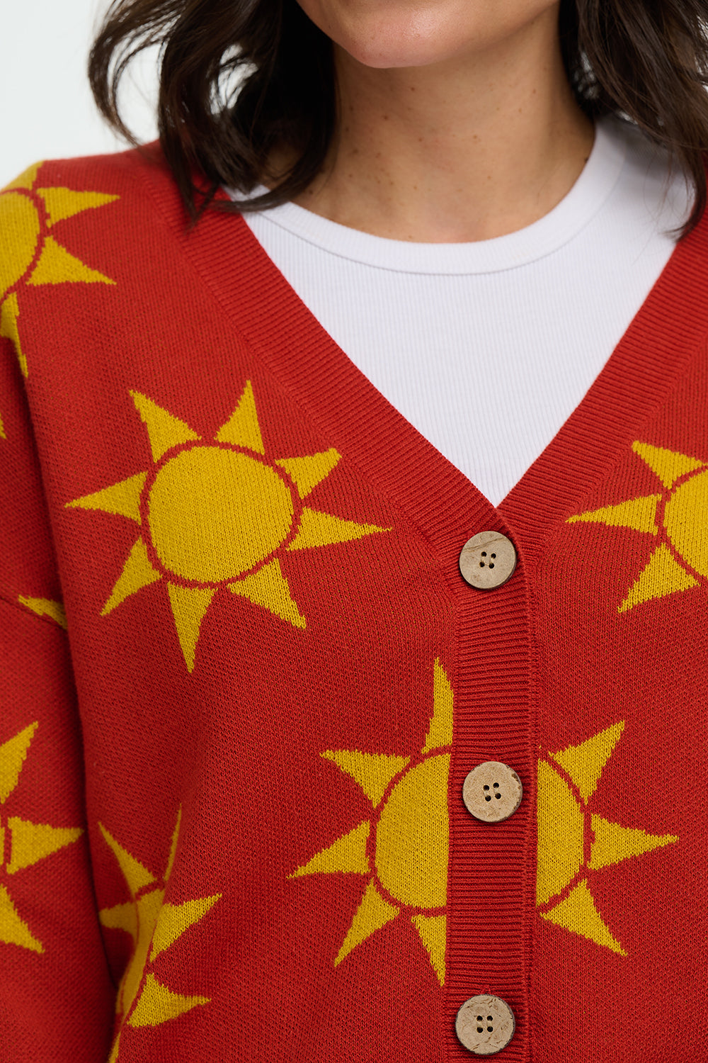 Red cardigan with yellow sun patterns worn by a person