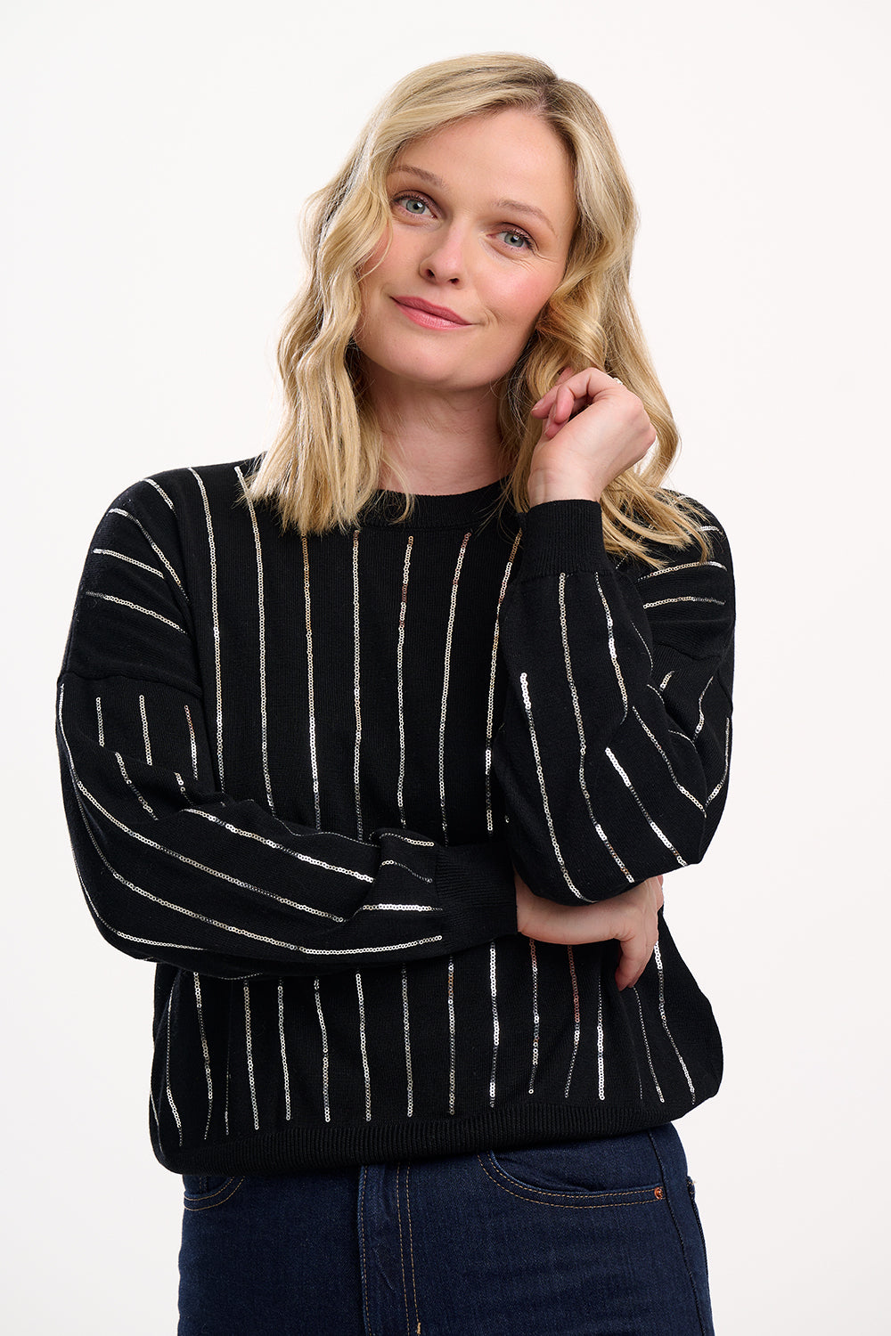 Woman wearing a black sweater with white stripes on a white background