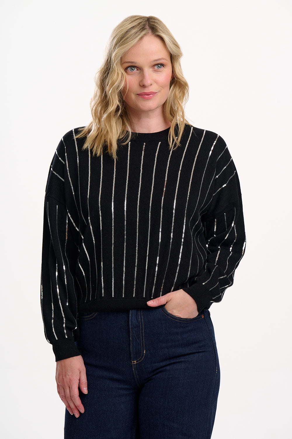 Woman wearing a black sweater with white pinstripes on a white background
