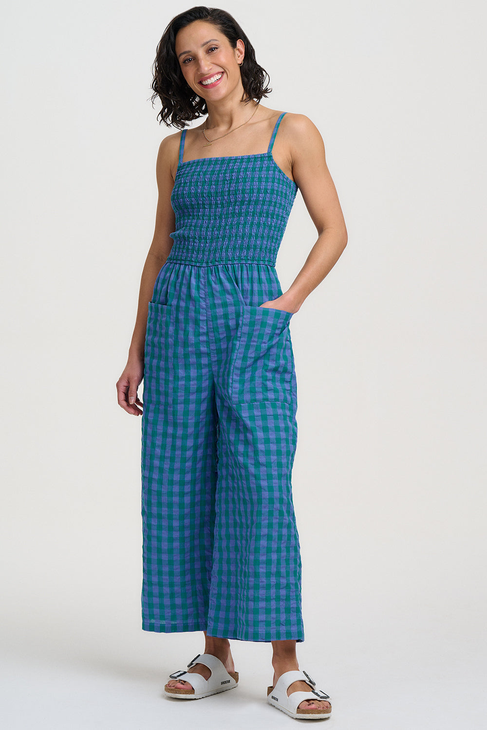 Woman wearing a blue checkered jumpsuit on a white background