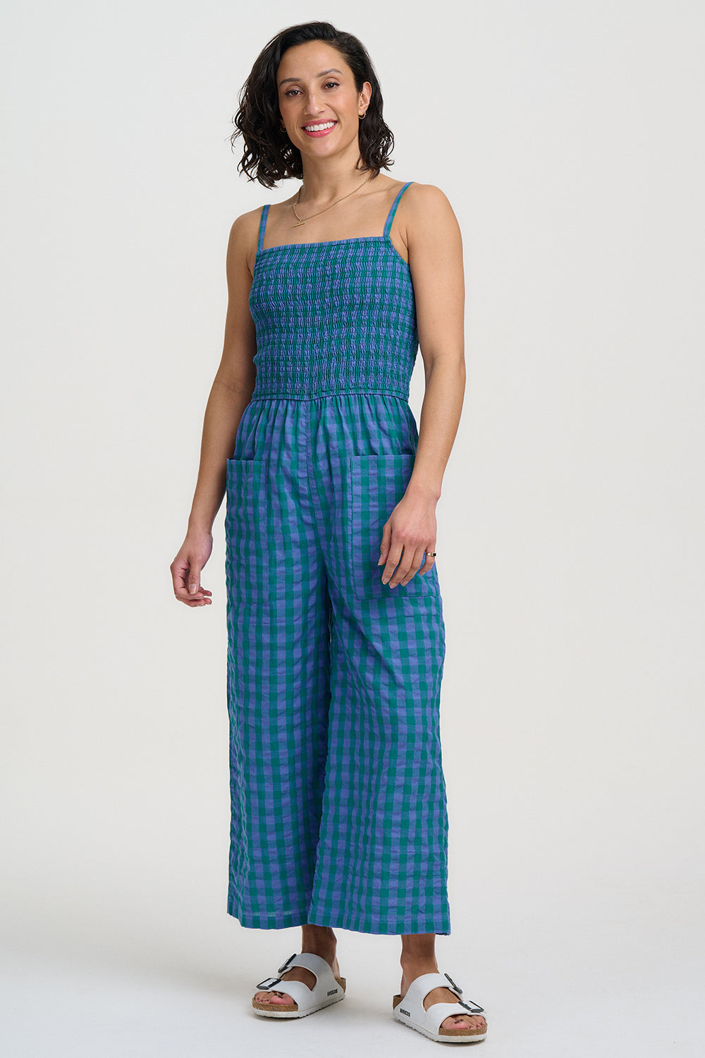 Woman wearing a blue checkered jumpsuit on a white background