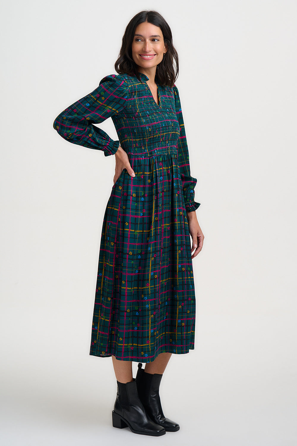 Woman wearing a plaid dress with long sleeves on a white background