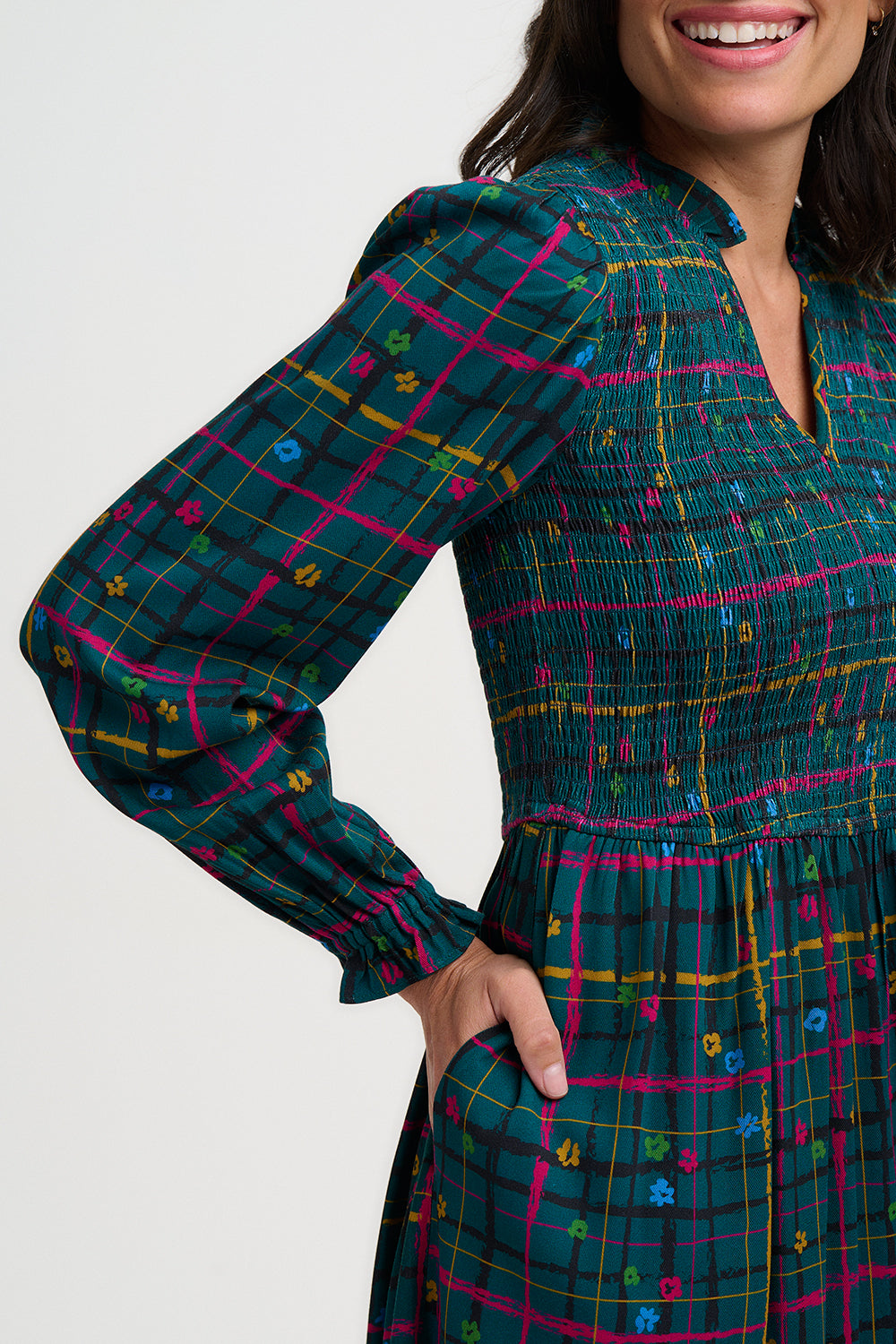 Woman wearing a plaid dress with colorful patterns on a white background