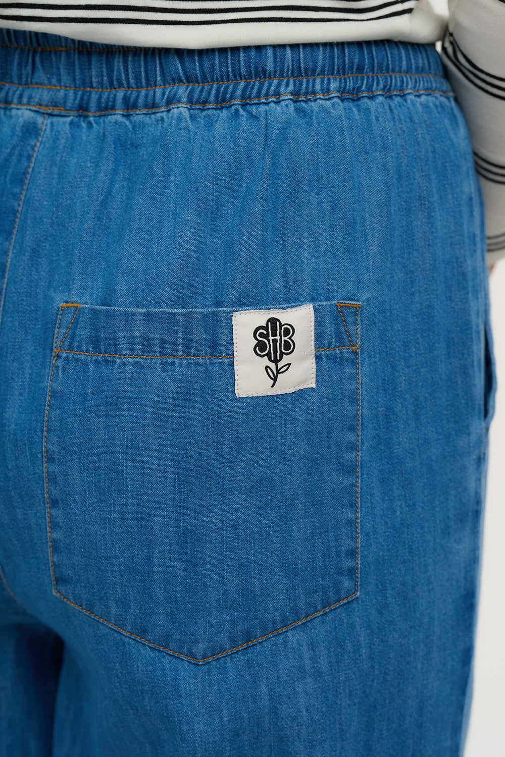 Blue denim pocket with a white label featuring a black design on a white background
