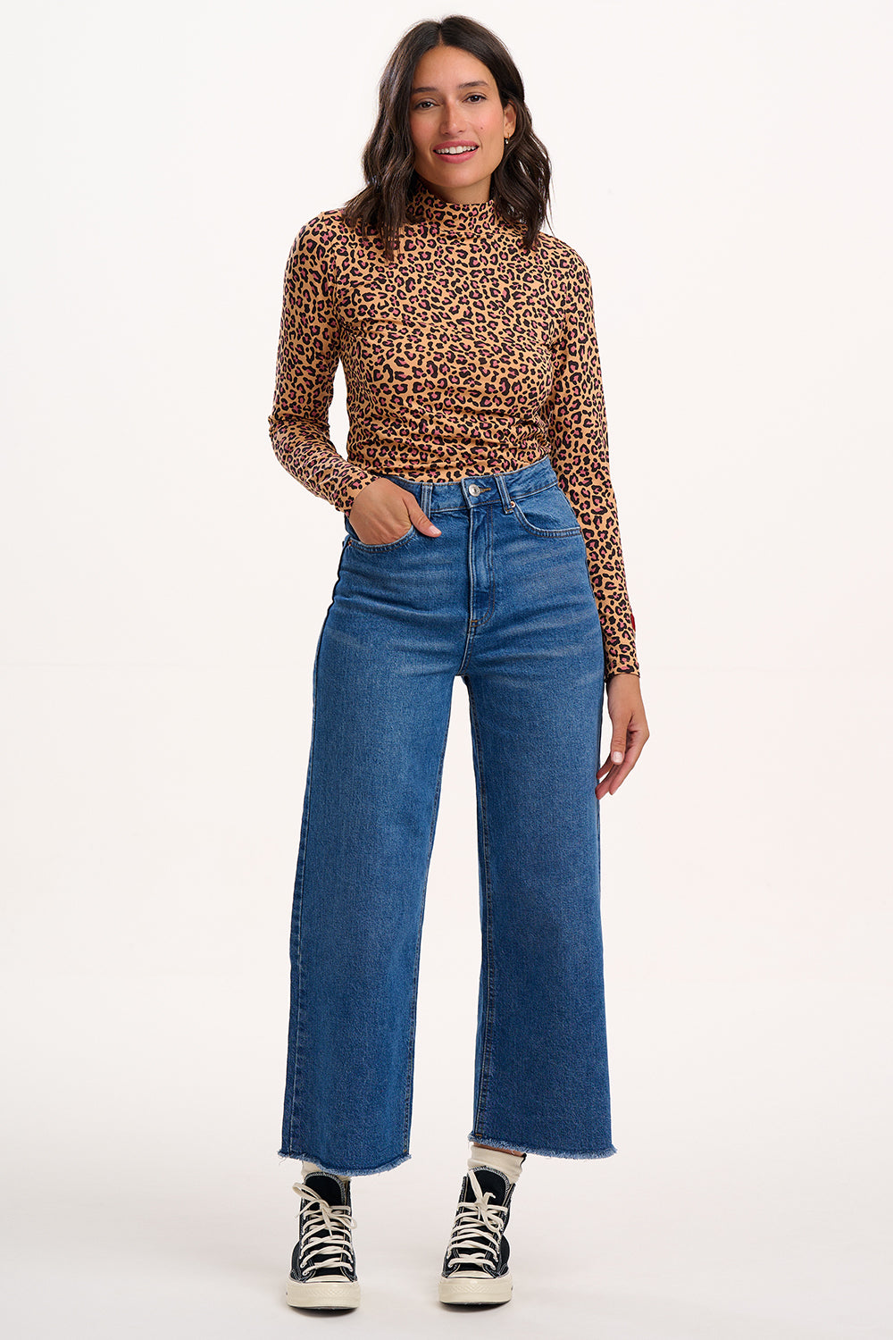 Sugarhill Brighton - Woman wearing a leopard print top and blue jeans on a white background