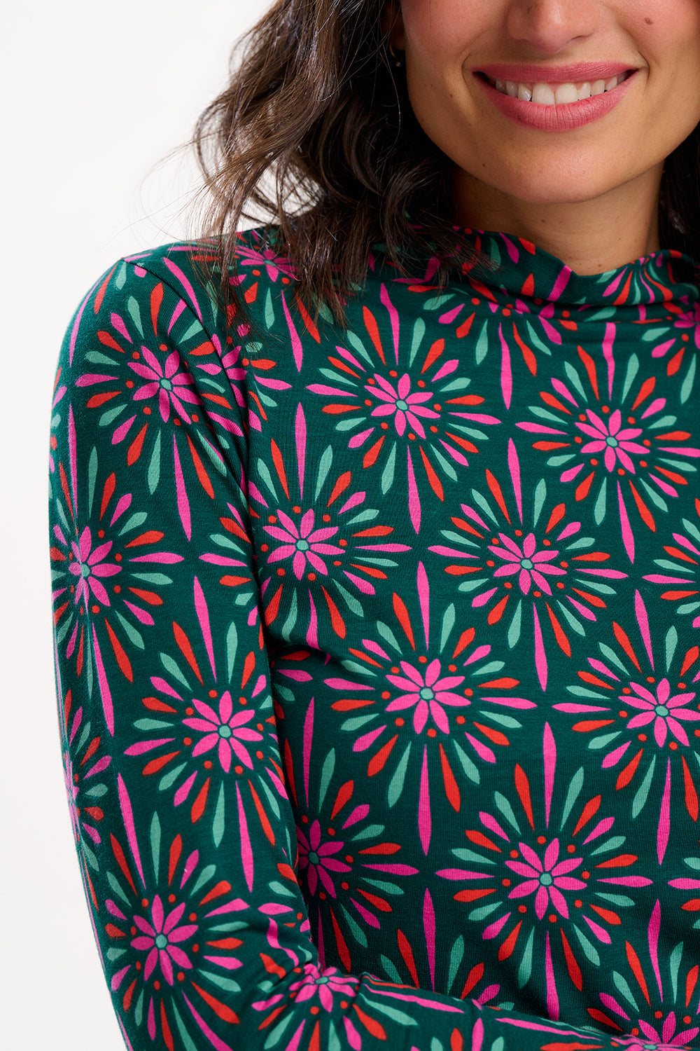 Person wearing a long-sleeve top with a vibrant floral pattern on a white background
