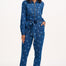 Woman wearing a blue denim jumpsuit with star pattern on a white background
