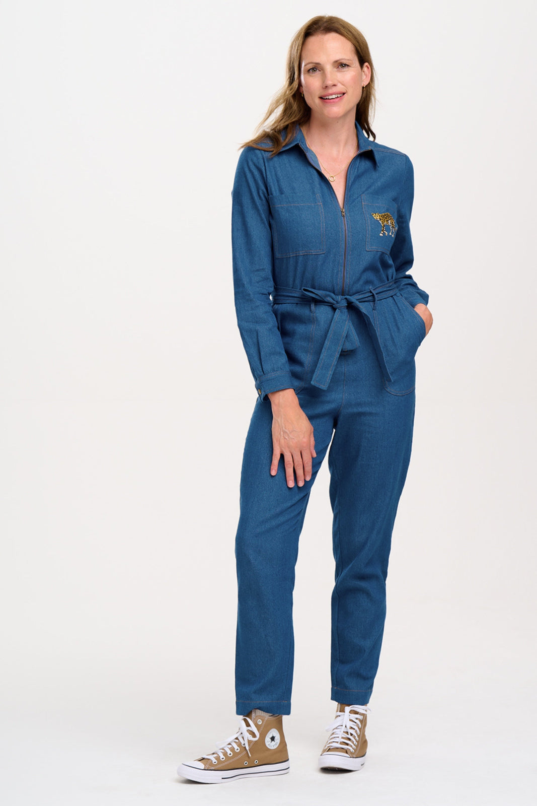 Woman wearing a blue jumpsuit with a logo on a white background