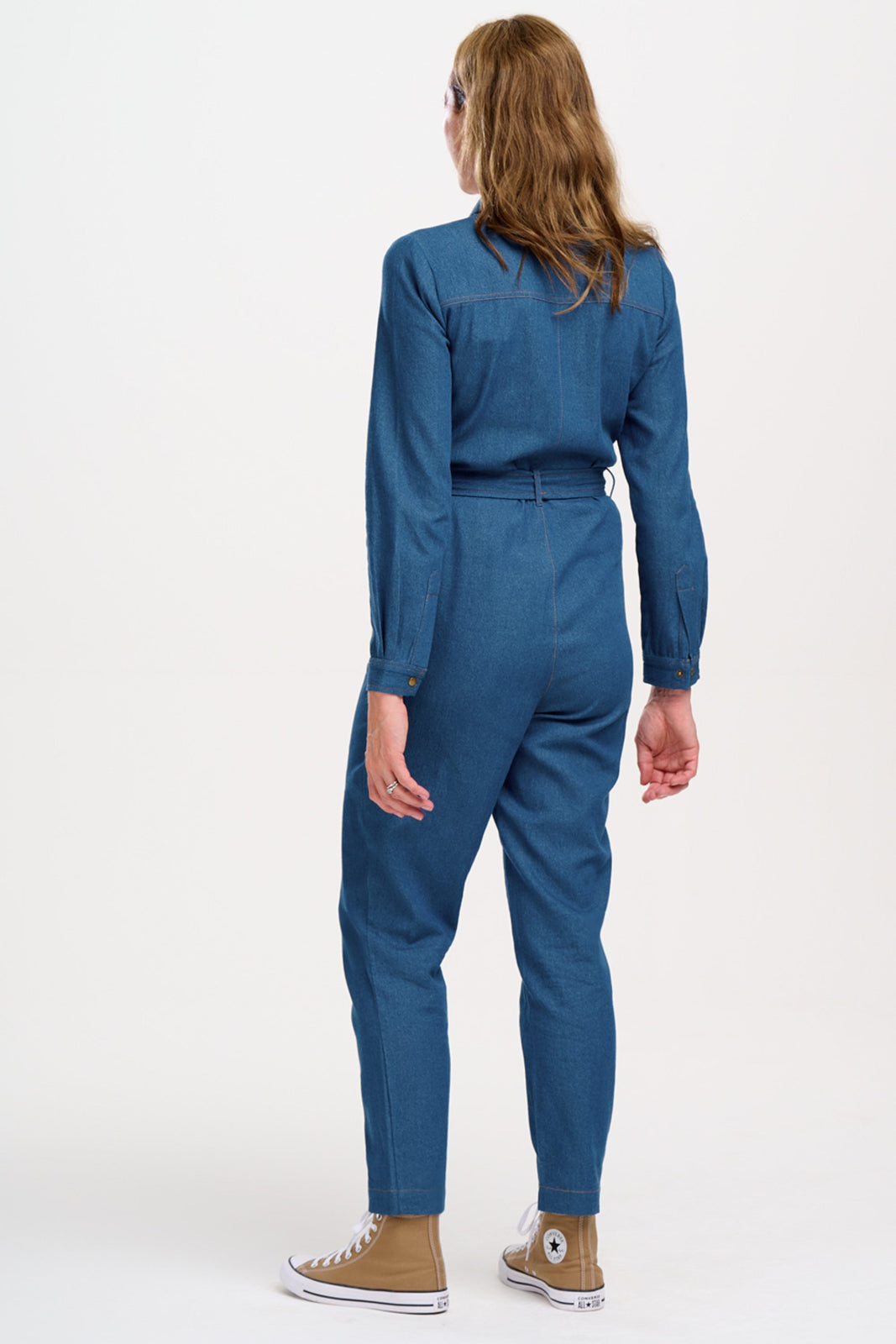 Person wearing a blue jumpsuit on a white background