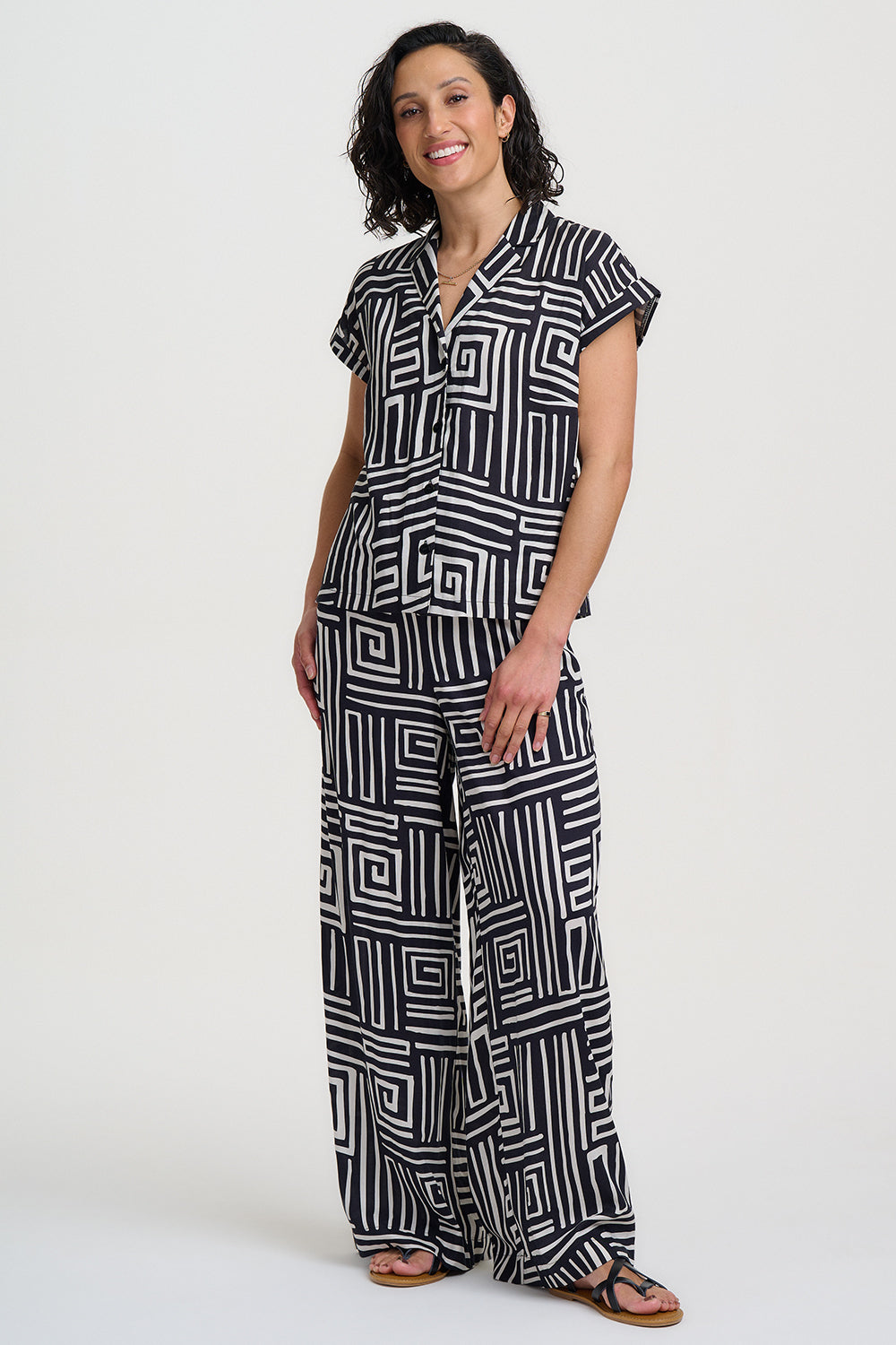 Woman wearing a black and white patterned jumpsuit on a white background
