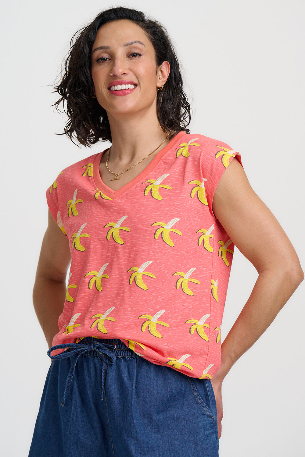 Woman wearing a pink t-shirt with banana print against a white background