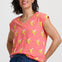 Woman wearing a pink t-shirt with banana print against a white background