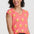 Woman wearing a pink shirt with banana print and blue shorts on a white background