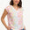 A woman wearing a white V-neck tank t-shirt with a rainbow pebble print