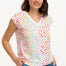A woman wearing a white V-neck tank t-shirt with a rainbow pebble print