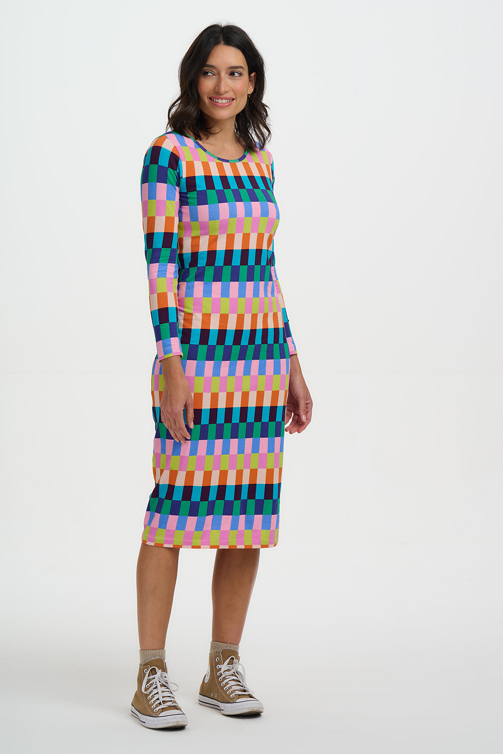 Woman wearing a colorful geometric patterned dress on a white background