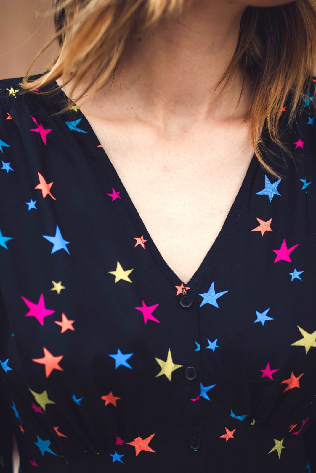 Navy blue shirt with colorful star pattern worn by a person