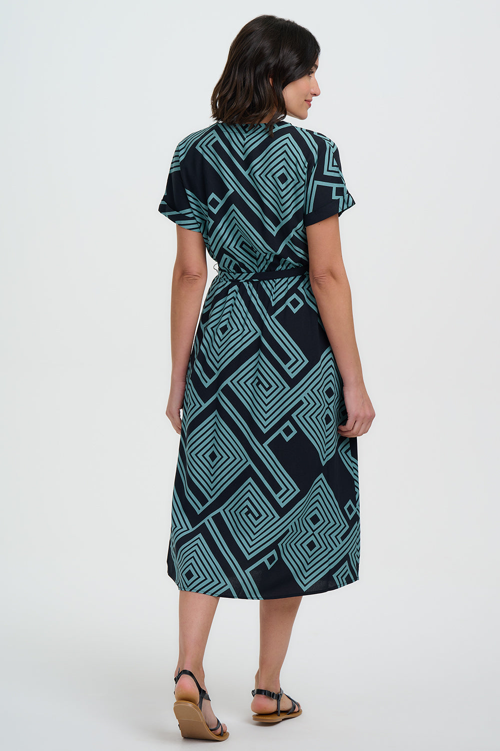 Woman wearing a green and black patterned dress on a white background
