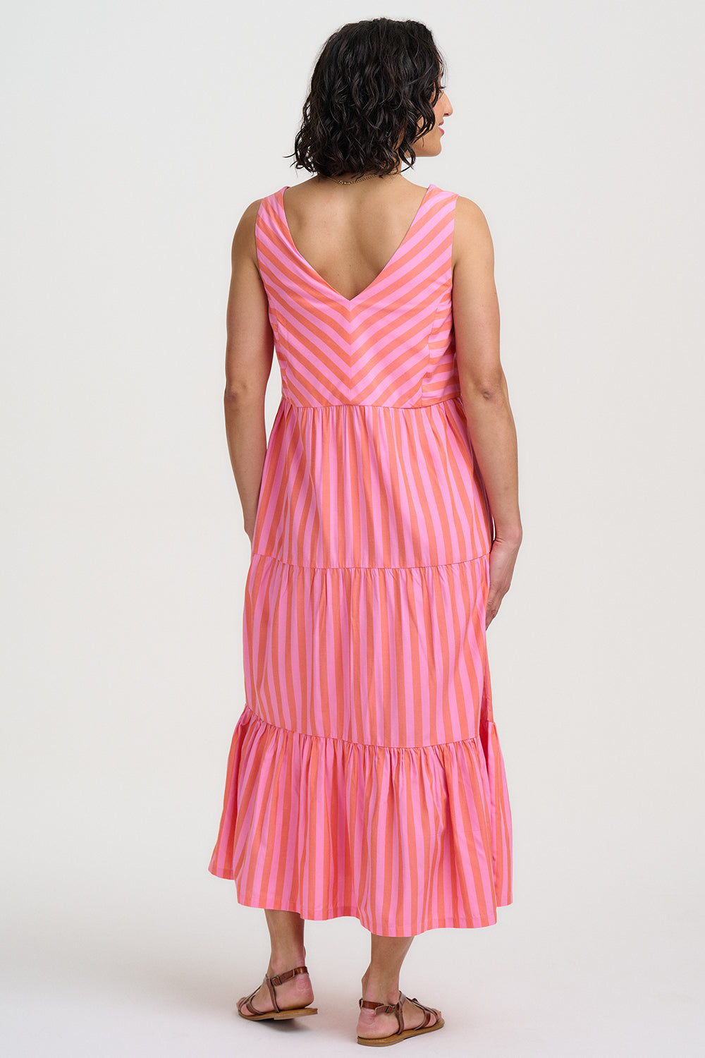 Woman wearing a pink and white striped dress on a white background