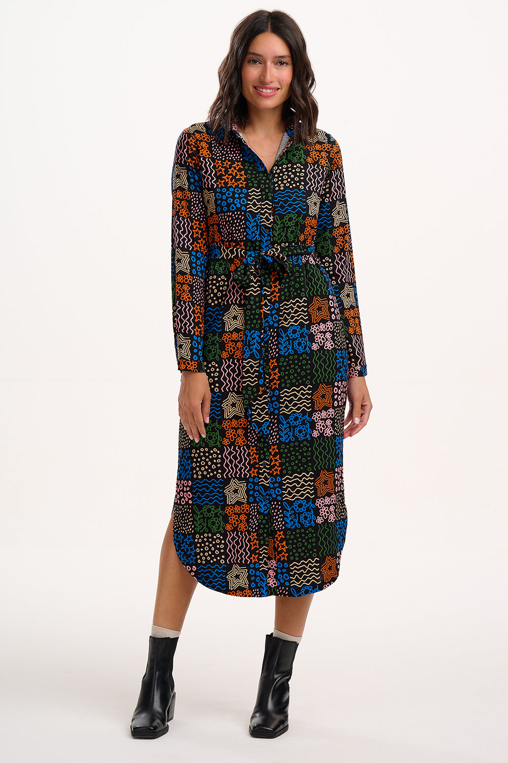 Woman wearing a colorful patterned dress on a white background