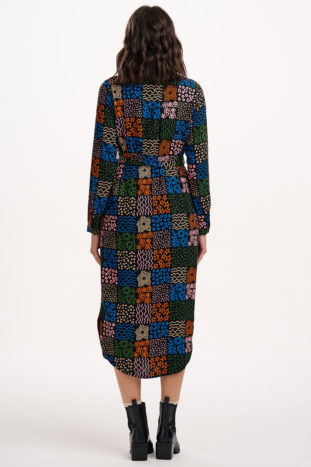 Multicolored patterned dress worn by a person on a white background